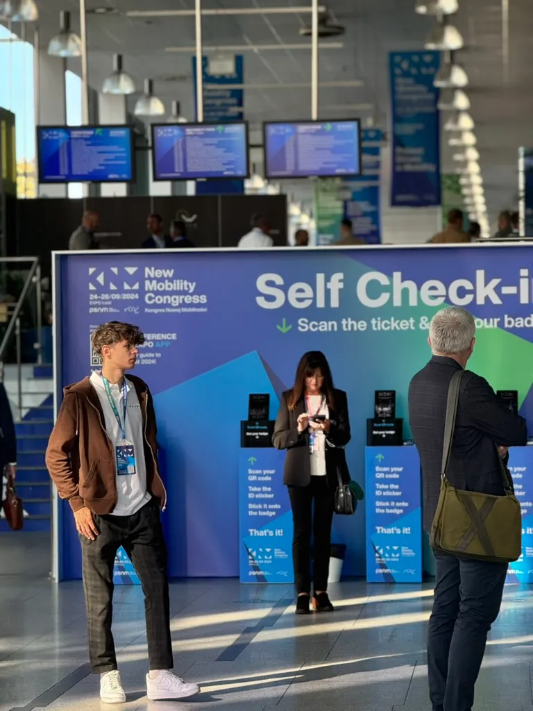 People using self-service check-in points at New Mobility Congress.