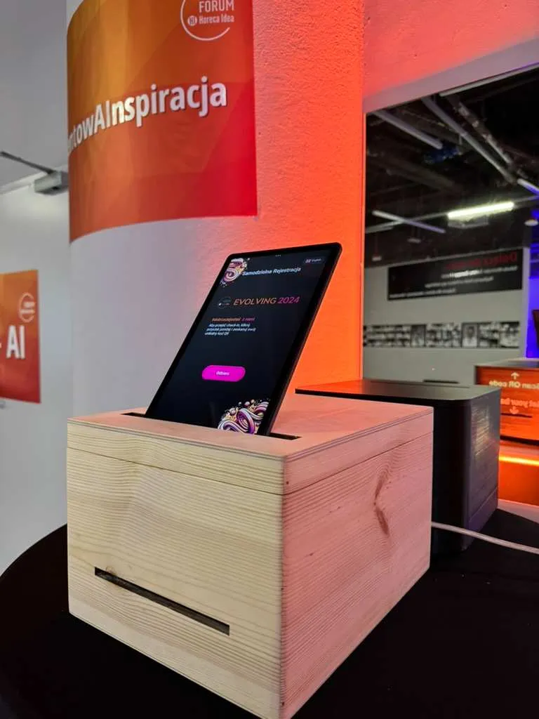 Tablet in wooden stand against orange wall with text Forum Horeca Idea.